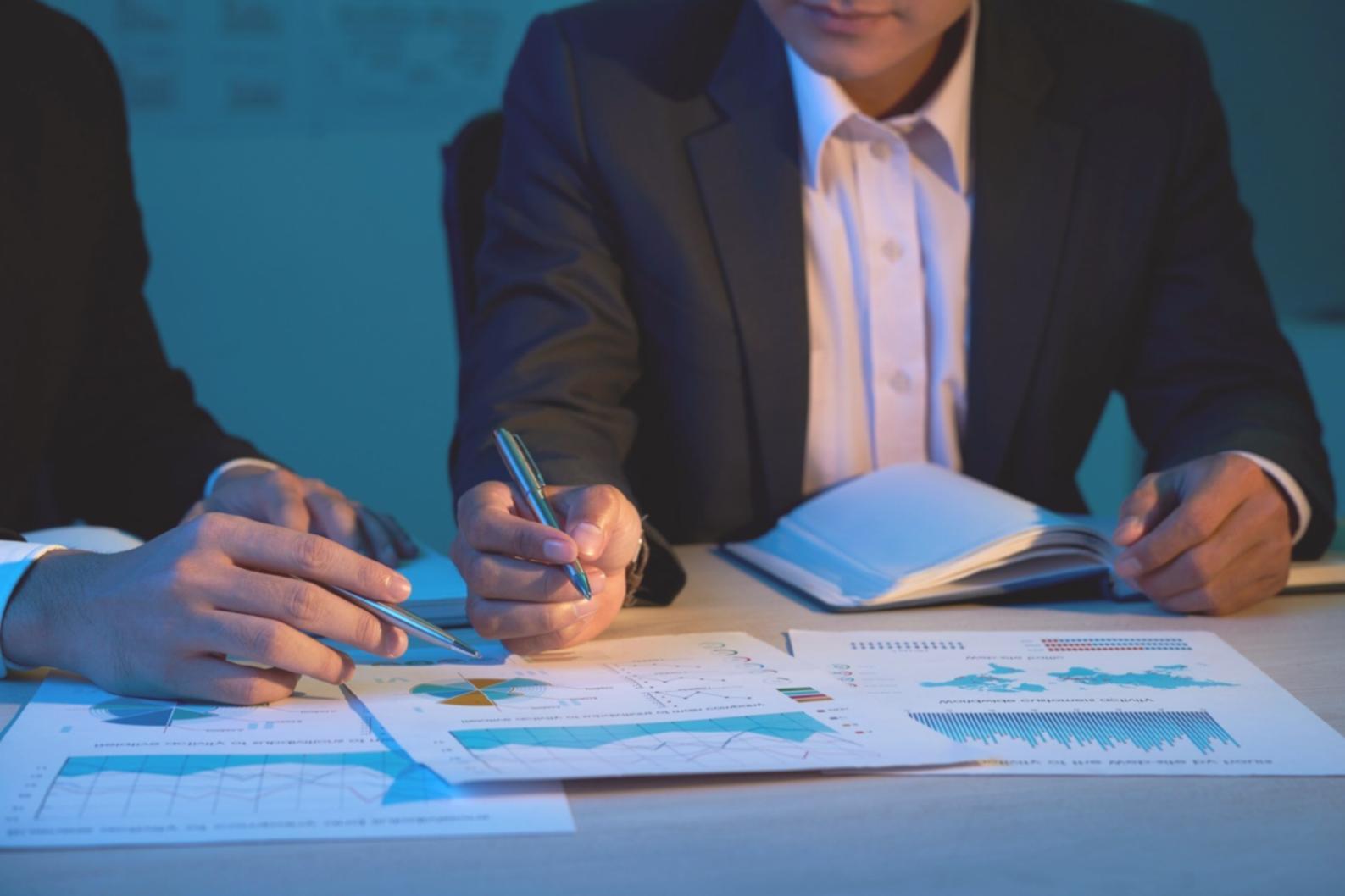 Person reviewing investment documents and financial planning materials